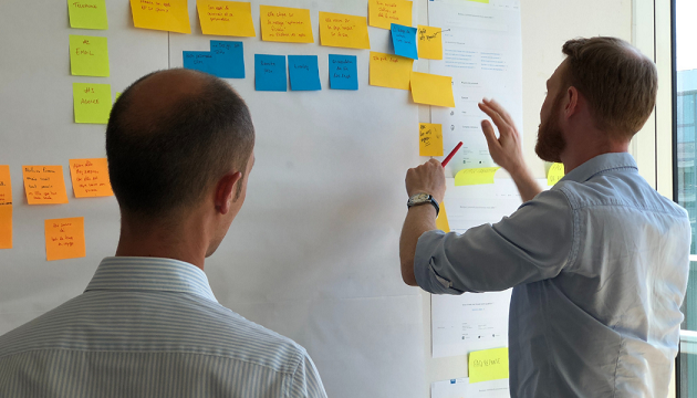 Two people planning workflow with sticky notes